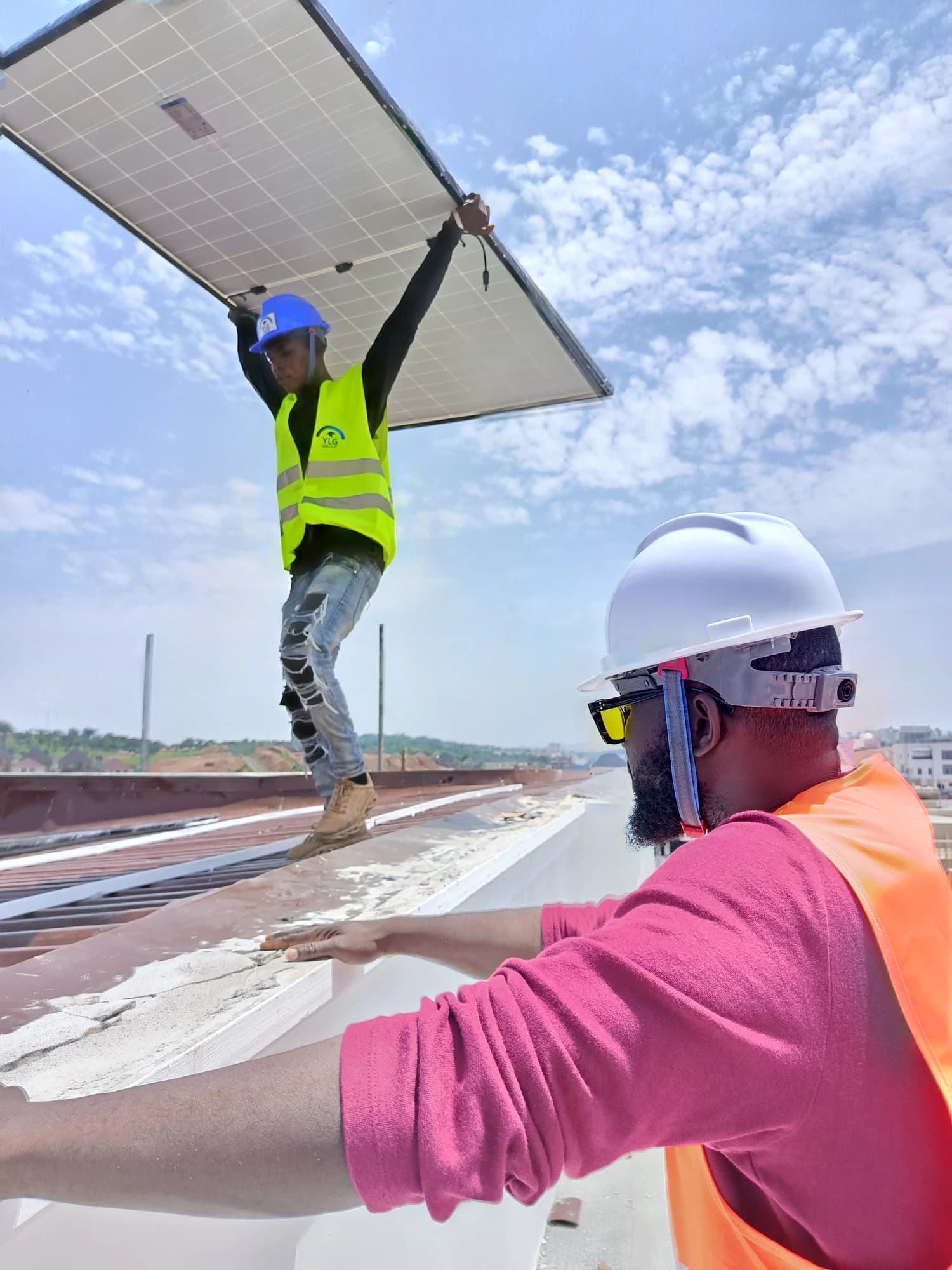 Solar installer lifting a photovoltaic panel on site